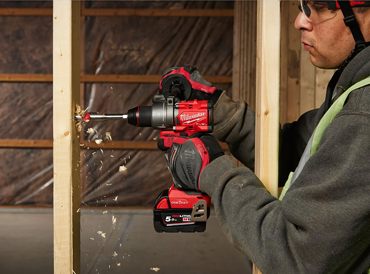 ouvrier utilisant une perceuse